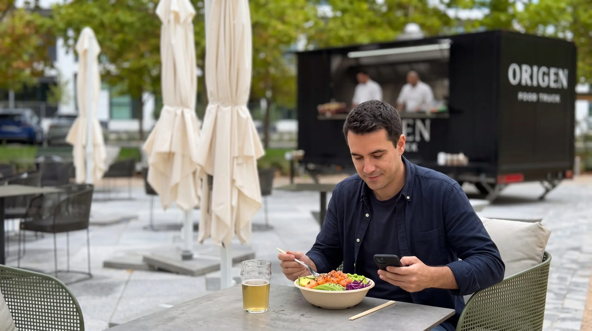 Comida en la terraza con el food truck al fondo